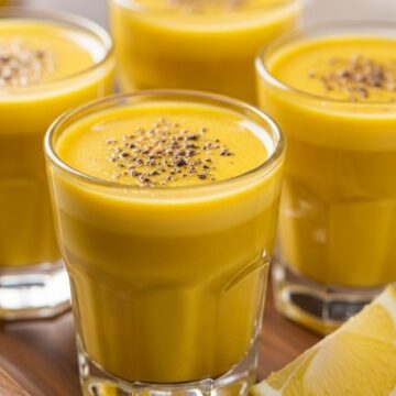 turmeric shots close-up on wooden tray with lemon