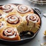 finished sourdough discard cinnamon rolls in cast iron pan