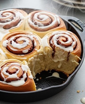 finished sourdough discard cinnamon rolls in cast iron pan