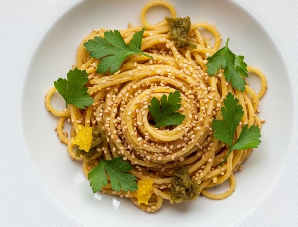 preserved lemon hummus pasta served in bowl with herbs
