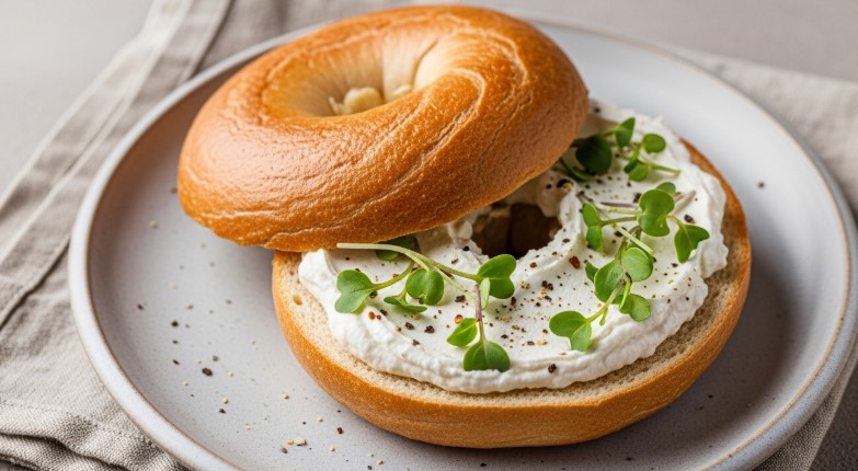 Toasted protein bagel with cream cheese and greens