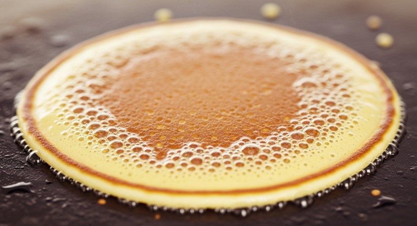 Pancake batter bubbling on griddle using Bisquick mix